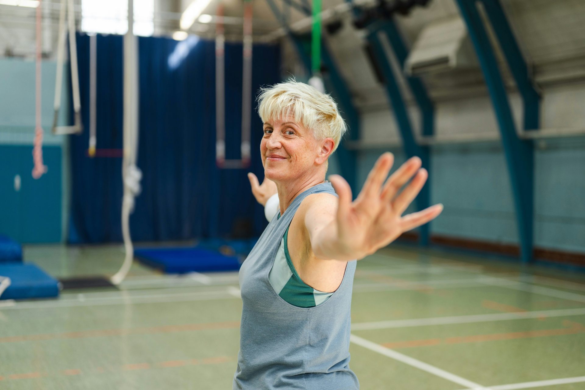An older woman with short blonde hair in a gym.